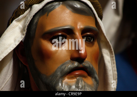 Un homme masqué vêtu comme un personnage biblique marche dans une rue au cours d'une procession de la Semaine Sainte de Pâques à Puente Genil, Espagne Banque D'Images