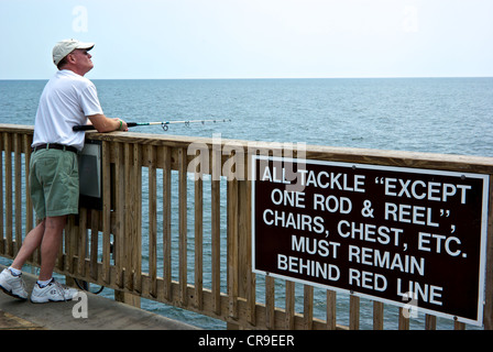 Pêche pêcheur mâle spinning reel Gulf Shores quai de pêcheurs du parc d'état de l'Alabama règles signe Banque D'Images