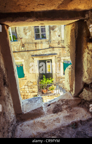 Un accueil et la porte avant dans la vieille ville de Dubrovnik encadrée par une fenêtre arch dans le mur de protection extérieure de la ville. Banque D'Images