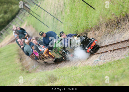 Un train à vapeur miniature mettant un train de touristes à un country park Banque D'Images