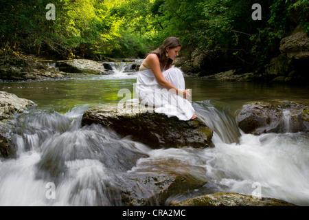 Belle jeune fille profitant de la purifier elle-même dans l'eau claire d'un ruisseau de montagne Banque D'Images