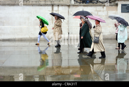 Les personnes qui s'y passé un mur dans la pluie Banque D'Images