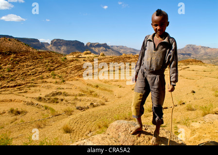 Garçon noir avec une coiffure mohawk debout devant le paysage aride du nord de l'Ethiopie, l'Éthiopie, l'Afrique Banque D'Images