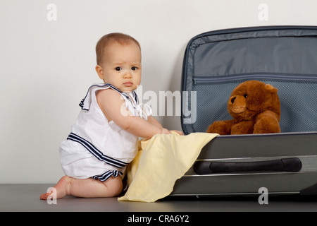 Portrait of a cute little baby avec ours en peluche dans suitcase Banque D'Images