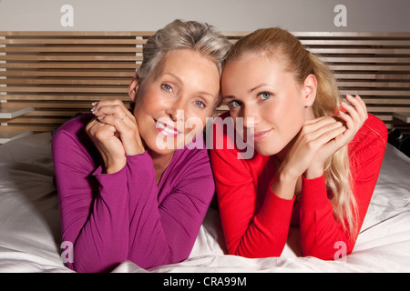Mère et fille sur le lit de pose Banque D'Images
