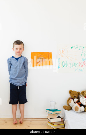 Garçon avec des dessins sur mur de la chambre Banque D'Images