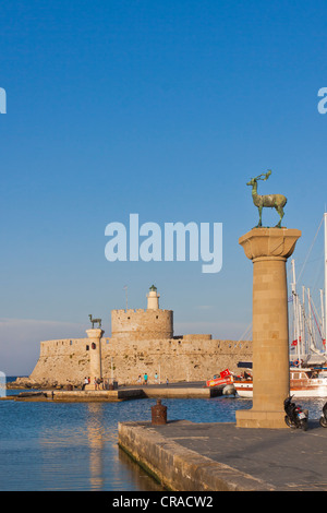 Et Elafos Elafina, cerf et biche sculptures sur des colonnes, avec la tour de la forteresse d'Agios Nikolaos, le port de Mandraki, Rhodes, Grèce Banque D'Images