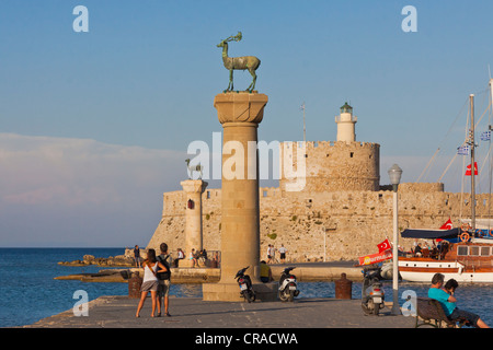 Et Elafos Elafina, cerf et biche sculptures sur des colonnes, avec la tour de la forteresse d'Agios Nikolaos, le port de Mandraki, Rhodes, Grèce Banque D'Images