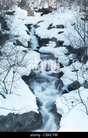 Chute d'eau de fonte en descendant les pentes d'une colline rocheuse Banque D'Images