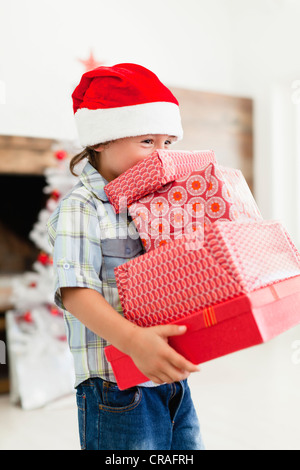 Boy in Santa hat with Christmas gifts Banque D'Images