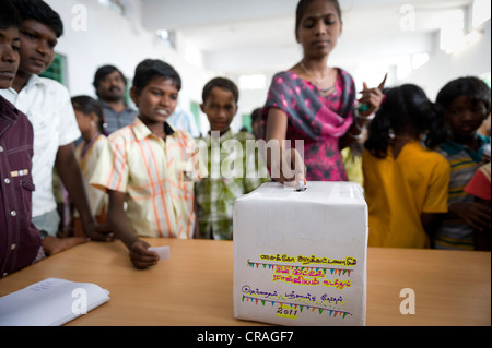 Bulletin de vote Girl putting dans Kutties Rajiyam fort, mini, élection Maravapalayam Noyyal panchayat, près de Karur, Tamil Nadu Banque D'Images