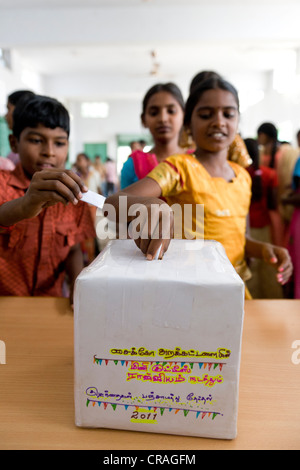 Bulletin de vote Girl putting dans Kutties Rajiyam fort, mini, élection Maravapalayam Noyyal panchayat, près de Karur, Tamil Nadu Banque D'Images