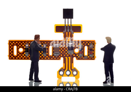 Deux hommes d'agir et à la perplexité en face d'un composant électronique, image symbolique pour l'analyse Banque D'Images