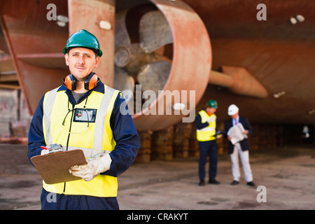 Presse-papiers sur Worker carrying dry dock Banque D'Images