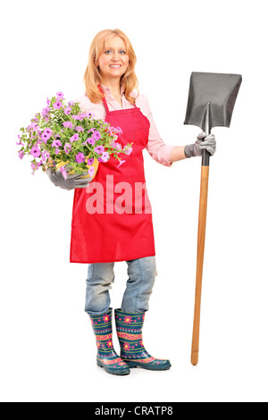 Portrait d'une femme tenant une pelle et jardinier fleurs isolé sur fond blanc Banque D'Images