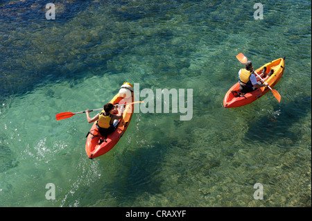 Père et fils en kayak dans les eaux cristallines de cala santa galdana menorca espagne iles baléares Banque D'Images