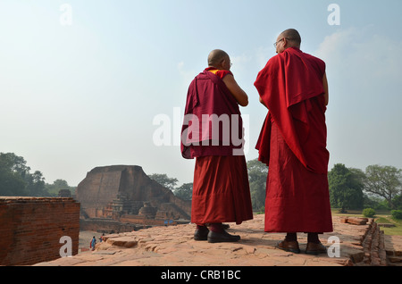 Le bouddhisme, moines tibétains portant des robes rouges au cours d'un pèlerinage sur le site archéologique de l'ancienne université de Nalanda, Banque D'Images