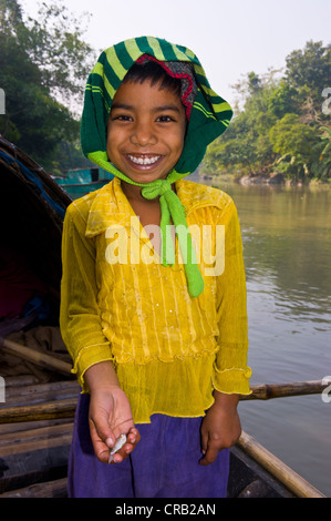 Friendly girl holding un petit poisson dans sa main, au Bangladesh, en Asie Banque D'Images