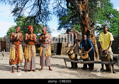 La danse des femmes comme un spectacle pour les touristes, les hommes avec des tambours, village traditionnel près du Camp sur la rivière Kwando Kwando Banque D'Images