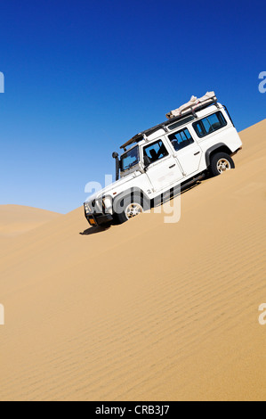 Landrover Defender véhicule hors route de descendre une immense dune, Namib-Naukluft National Park, Skeleton Coast National Park Banque D'Images