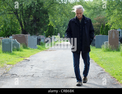 Middle aged man walking in cemetery, la tête en bas. Banque D'Images
