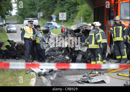 Les agents de police et les pompiers, l'unité médico-légale la conservation de preuves après l'accident mortel de la circulation de l'épave d'une Audi A3 Banque D'Images