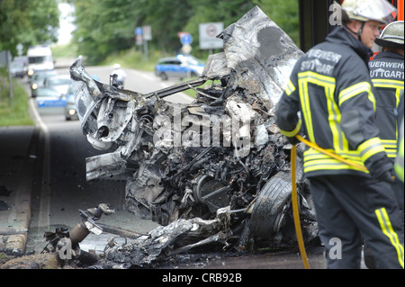 Les pompiers participant à l'épave d'une voiture Audi qui a été détruit et brûlé au-delà de la reconnaissance, Sindelfingen Banque D'Images