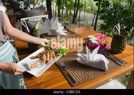 Waitress serving Thai Food, The Seven Seas Resort, Ko Kradan, Trang, Thaïlande, Asie du Sud-Est, Asie Banque D'Images