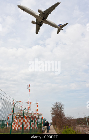 Approche de l'aéroport avion volant au-dessus de la tête des marcheurs, Francfort, Hesse, Germany, Europe Banque D'Images