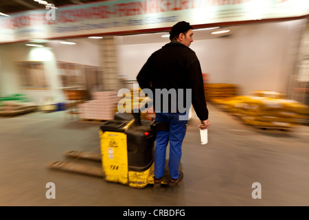 Disques durs travailleurs avec levée des marchandises dans un commerce de gros en produits frais, fruits et légumes, Francfort, Hesse, Germany, Europe Banque D'Images