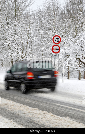 Route de campagne couverte de neige en hiver, obligatoire-signe, signe d'interdiction, la voiture, le motion blur Banque D'Images