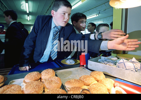 Les élèves obtenir leur dîner dans la cantine scolaire de l'école Veralum, Hertfordshire, England, UK. Banque D'Images