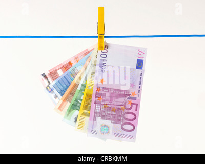 Fan de billets accrochés sur une corde à linge, image symbolique pour le blanchiment d'argent illégal, Banque D'Images
