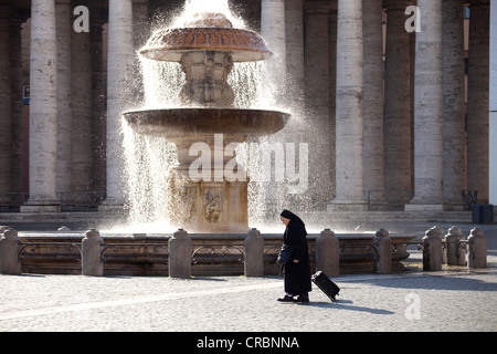 Nun en face d'une fontaine dans la place Saint Pierre à Rome, Italie, Europe Banque D'Images