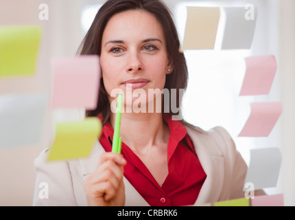 Businesswoman reading notes adhésives Banque D'Images