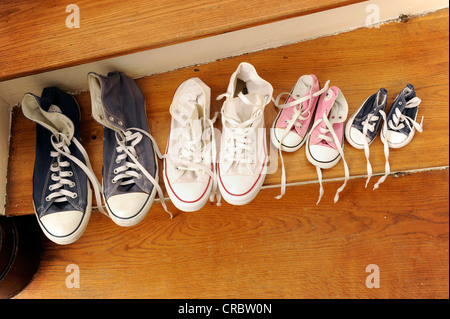 Les chaussures de sport d'une famille avec deux enfants, alignés sur un escalier Banque D'Images