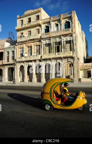 Coco Taxi, un scooter à moteur couverte du Malecon, Avenida de Antonio Maceo, un boulevard le long du centre-ville de La Havane Banque D'Images