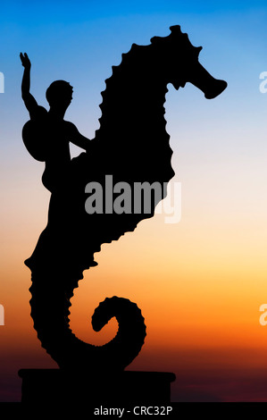 Silhouette de Puerto Vallarta's iconic 'Seahorse' sculpture 'El Cabalito' par Rafael Zamarripa sur le Malecon au coucher du soleil. Banque D'Images