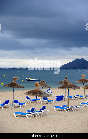 Transats et parasols sur une plage, ciel couvert, Puerto de Pollensa, Pollensa, Mallorca, Majorque, Iles Baléares Banque D'Images