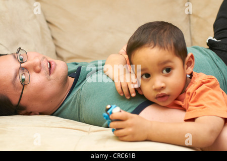 Père et fils relaxing on sofa Banque D'Images