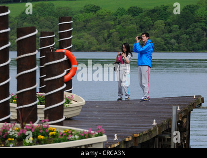 Les touristes de prendre une photo sur la jetée de Duck Bay sur le Loch Lomond Banque D'Images