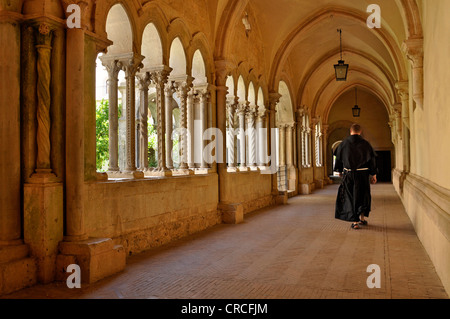 Monk marche dans le cloître avec double colonne de la basilique gothique de l'abbaye de Fossanova le monastère cistercien Banque D'Images