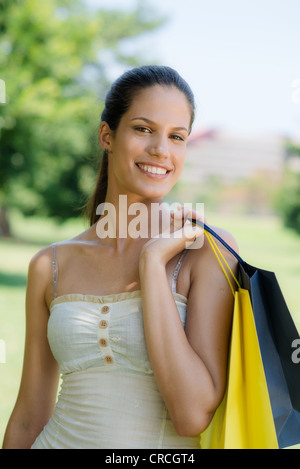 Le consumérisme, portrait of happy young woman smiling at camera with shopping bags Banque D'Images