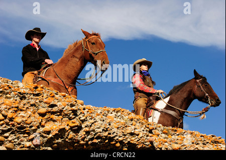 Cowboy et cowgirl sur les chevaux à la recherche dans la distance, de la Saskatchewan, au Canada, en Amérique du Nord Banque D'Images