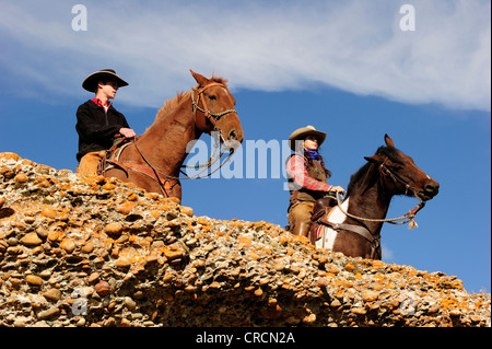 Cowboy et cowgirl sur les chevaux à la recherche dans la distance, de la Saskatchewan, au Canada, en Amérique du Nord Banque D'Images