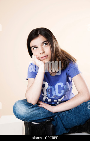 Girl sitting on table looking up Banque D'Images