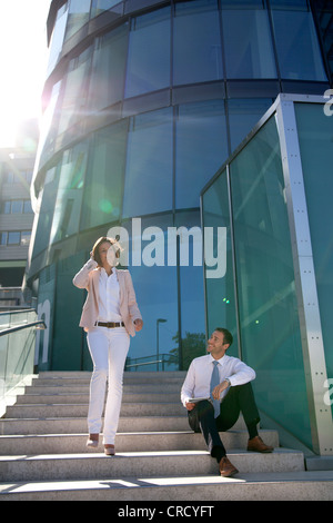 Smiling businessman and businesswoman on stairs Banque D'Images