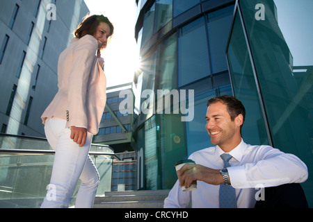 Smiling businessman and businesswoman on stairs Banque D'Images