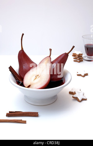 Poires au vin rouge, des bâtons de cannelle et les biscuits de Noël Banque D'Images