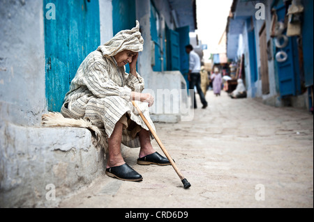 Vieil homme à la recherche de l'emplacement dans les rues de la médina de Chefchaouen Banque D'Images